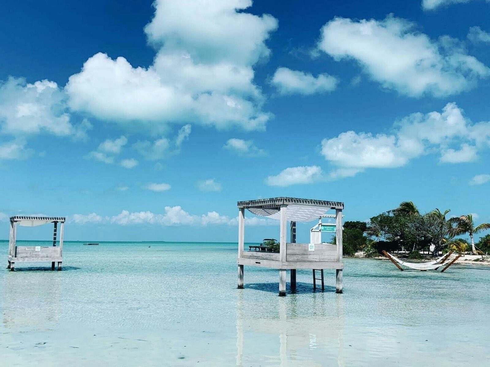 Overwater wooden cabanas standing in crystal-clear Caribbean water, Belize