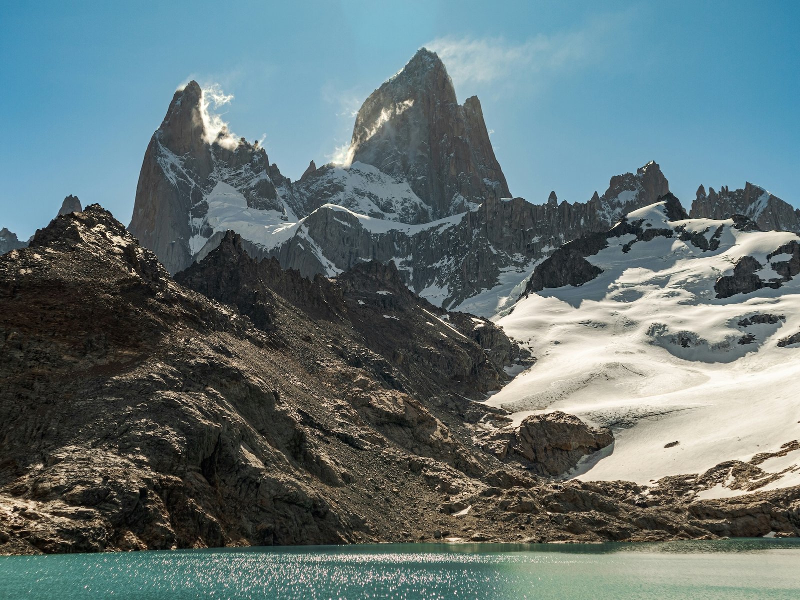 The jagged granite spires of Fitz Roy rise above a turquoise glacial lake in Argentine Patagonia