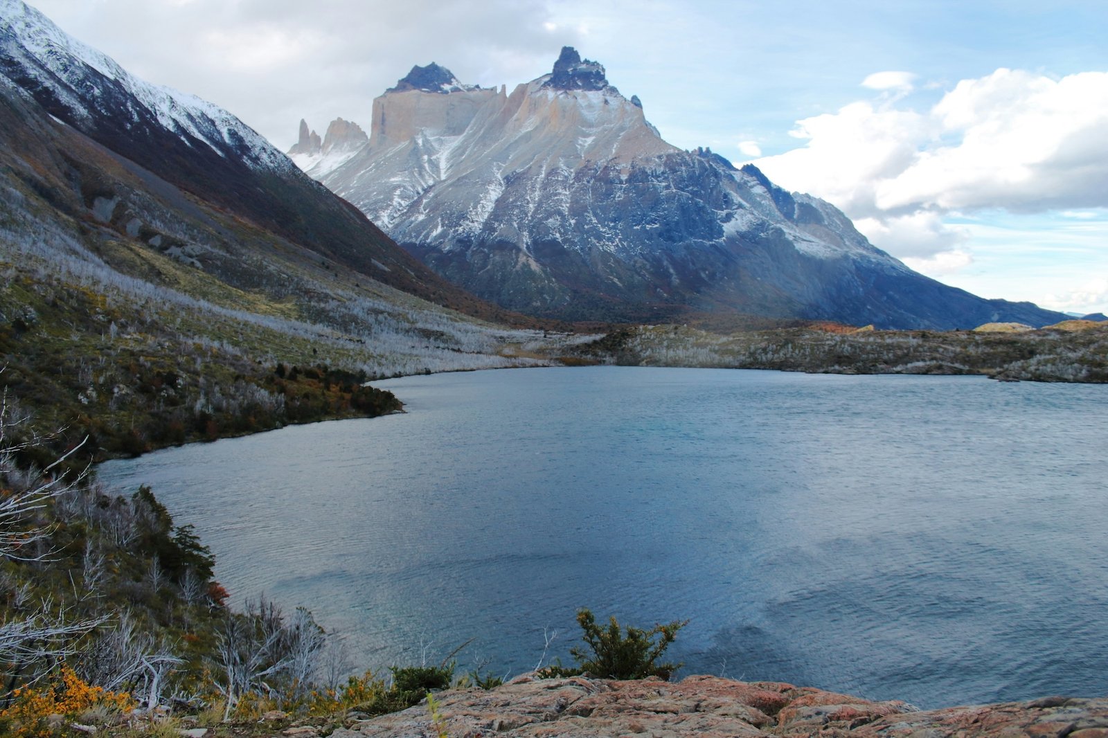 A glacial lake reflects the Torres del Paine massif under an autumn sky